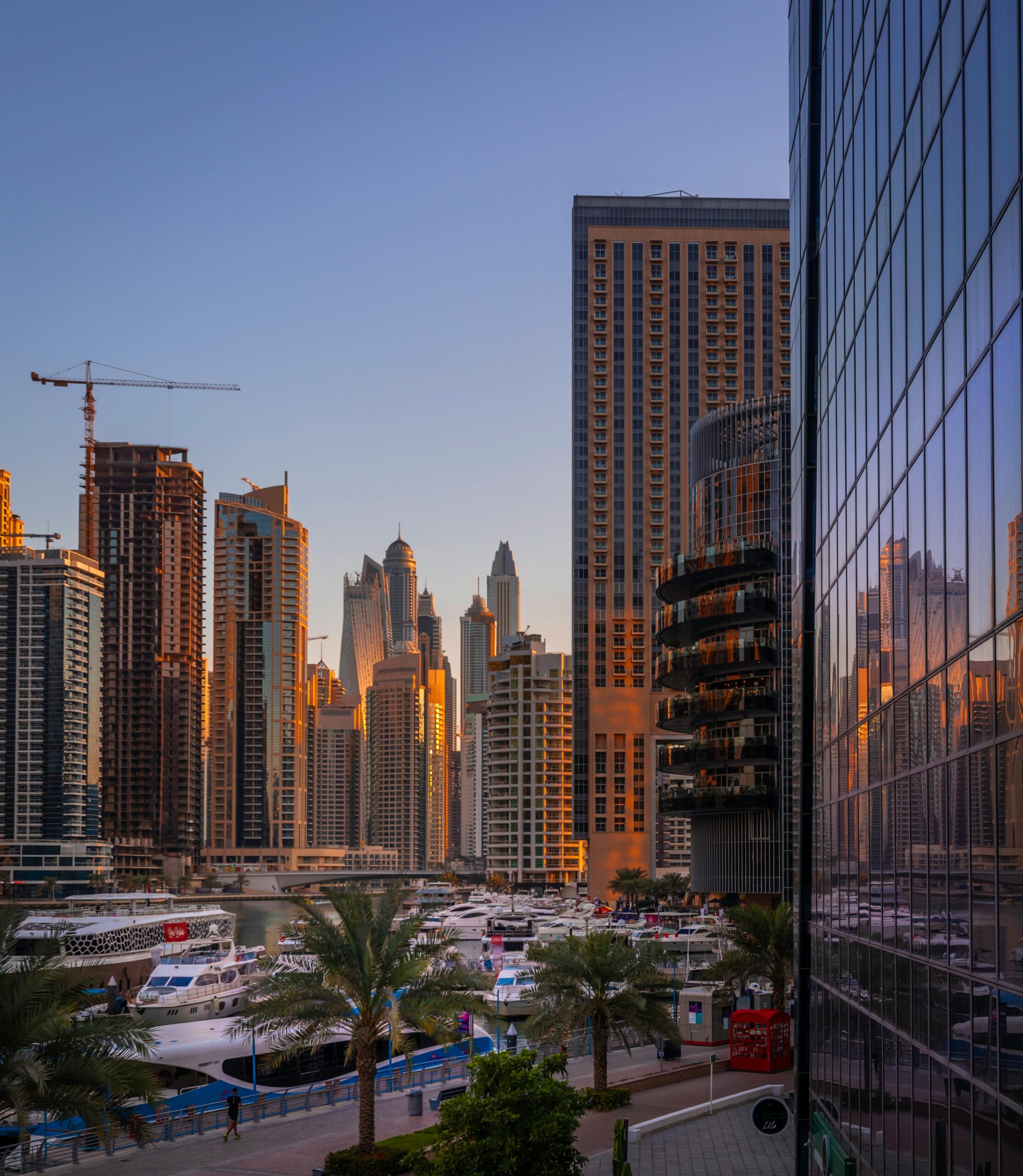 Captivating view of Dubai Marina's skyline with yachts at sunset, reflecting modern architecture.